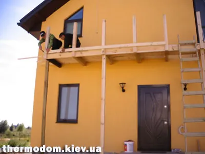 Будівельники роблять підлогу дерев'яного балкона