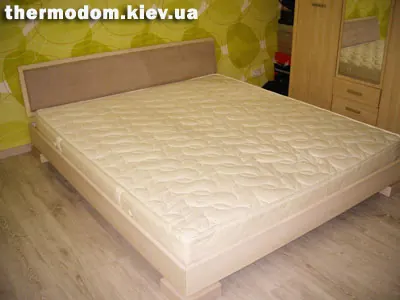 Дерев'яне ліжко з м'яким узголів'ям