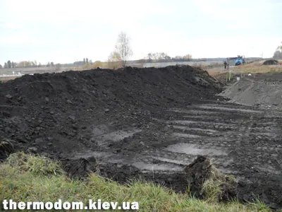 Снятый чернозем сгребен к границе участка
