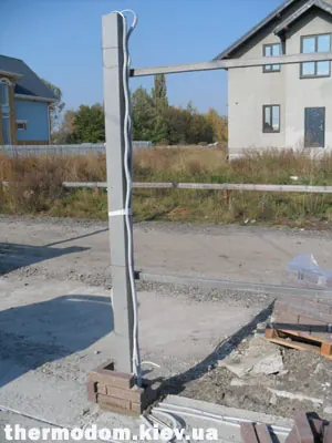 Железный столб забора с проводом