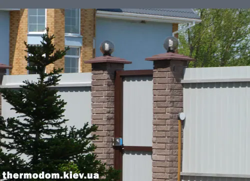 Круглые затемненные светильники-шары на столбиках забора
