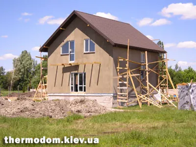 Будинок з вікнами й купами ґрунту перед ним